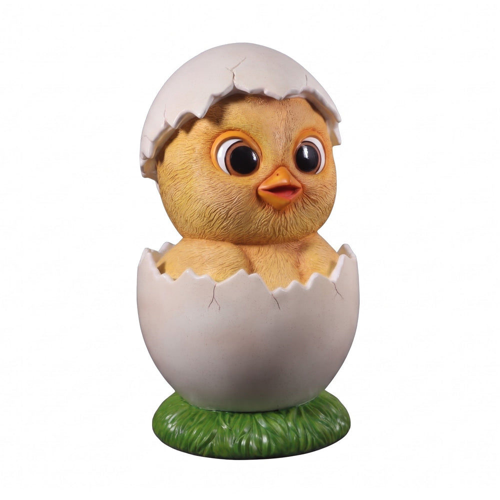 Heinimex Easter Chick 4ft event prop, textured yellow finish with cracked white eggshell and green grass base, playful outdoor spring display style angle view