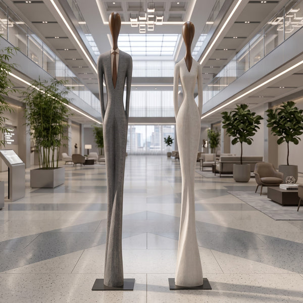 Heinimex Paya and Payo elongated human figure statues, textured stone-look and smooth wood-tone finish, modern minimalist gallery lifestyle setting.