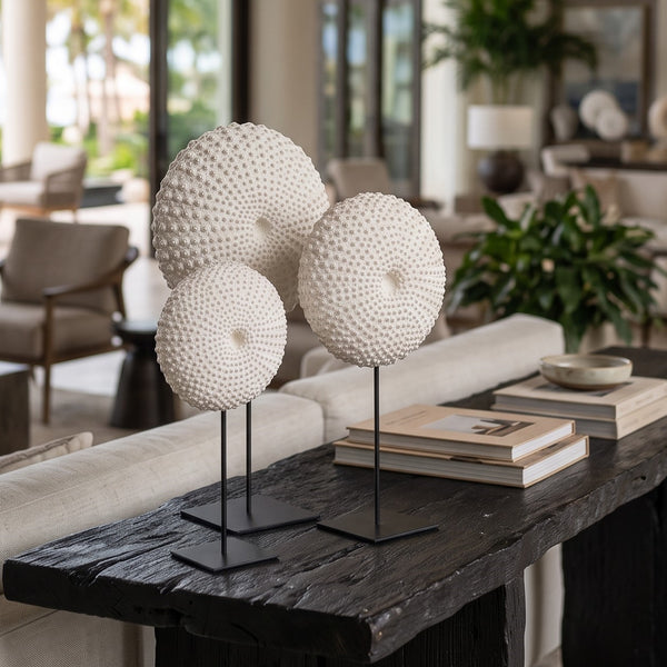 Heinimex Sea Urchin on Stand centerpiece, textured white stone finish with black metal stand, modern coastal luxury lifestyle photo in set