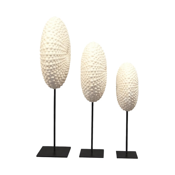 Heinimex Sea Urchin on Stand centerpiece, textured white stone finish with black metal stand, modern coastal luxury style in set side view