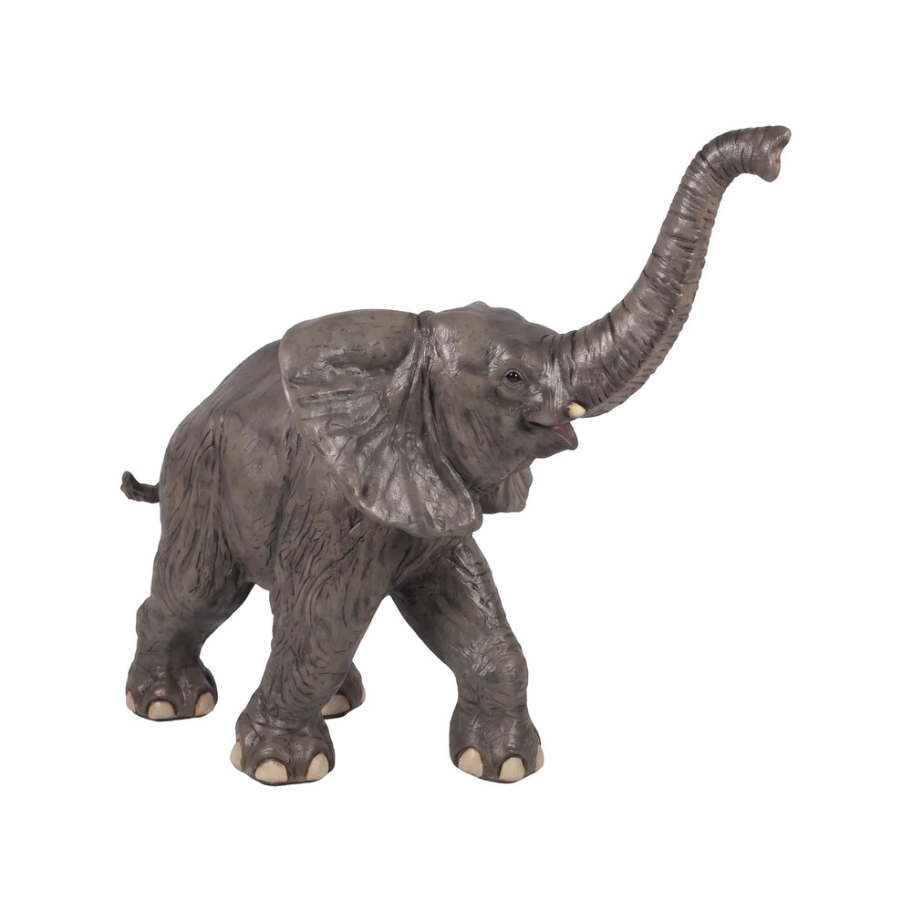 Decorative statue of a walking baby elephant featuring textured grey skin, large flared ears, and a high raised trunk.