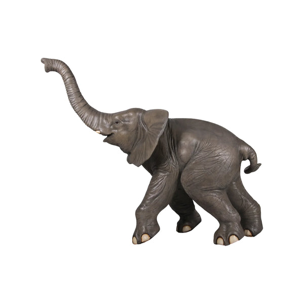 Decorative statue of a walking baby elephant featuring textured grey skin, large flared ears, and a high raised trunk.