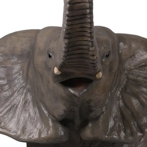 Decorative statue of a walking baby elephant featuring textured grey skin, large flared ears, and a high raised trunk.