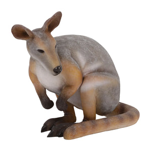 Decorative statue of a crouching wallaby featuring a grey and tan coat, upright ears, and a thick tail resting on the ground.