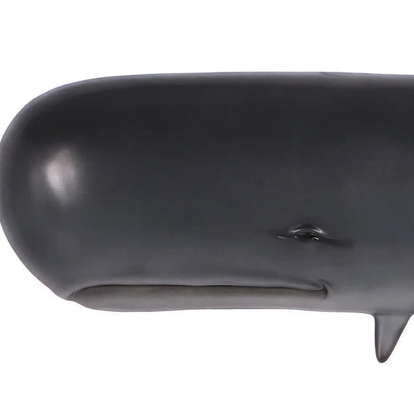 Decorative wall-mounted sculpture of a dark grey sperm whale featuring a prominent blunt head and a raised, curved tail.