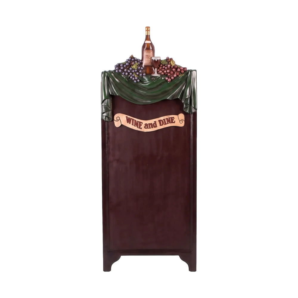 Decorative freestanding menu board featuring a dark writing surface topped with a sculpted wine bottle, grapes, and a Wine and Dine banner.