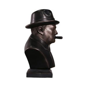 Decorative dark bronze-finished bust of Winston Churchill wearing a hat and bow tie, with a sculpted cigar in his mouth.