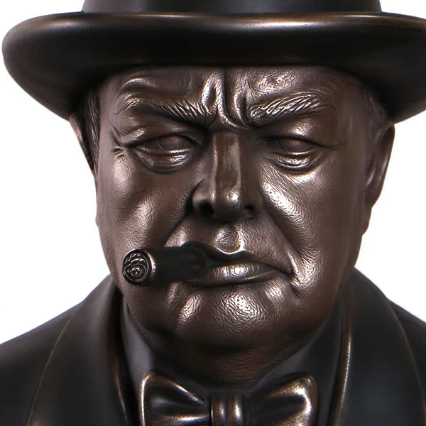 Decorative dark bronze-finished bust of Winston Churchill wearing a hat and bow tie, with a sculpted cigar in his mouth.