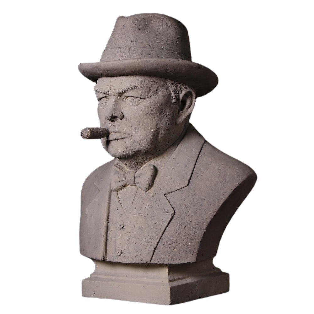 Decorative grey stone-like bust of Winston Churchill wearing a hat and bow tie, with a sculpted cigar in his mouth.