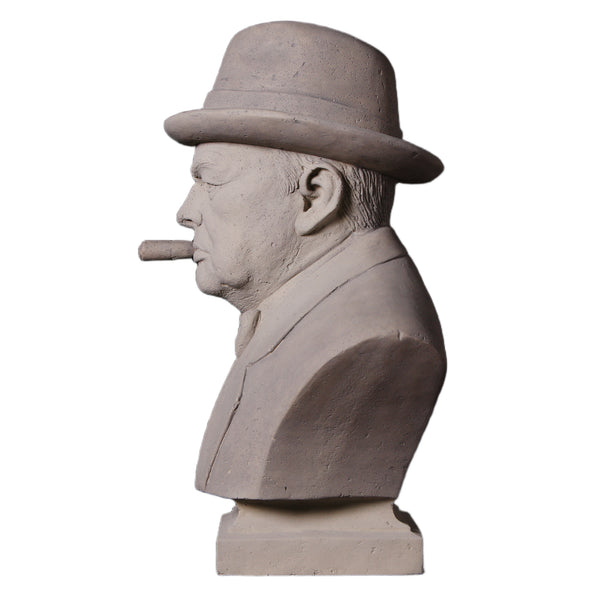 Decorative grey stone-like bust of Winston Churchill wearing a hat and bow tie, with a sculpted cigar in his mouth.