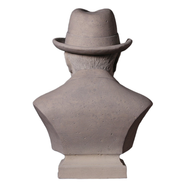 Decorative grey stone-like bust of Winston Churchill wearing a hat and bow tie, with a sculpted cigar in his mouth.