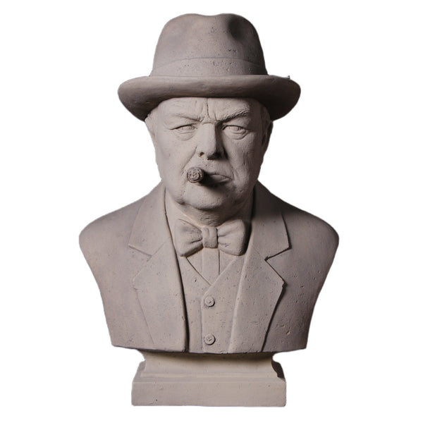 Decorative grey stone-like bust of Winston Churchill wearing a hat and bow tie, with a sculpted cigar in his mouth.
