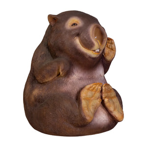 Decorative statue of a smiling wombat sitting upright with a brown finish and large textured foot pads.