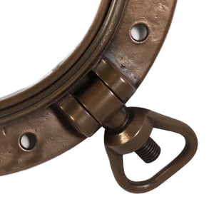 Decorative nautical porthole window featuring a bronze-colored frame and hinged locking bolts.