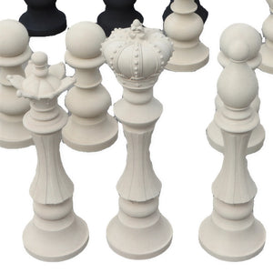 Decorative set of black and white chess pieces featuring traditional shapes like kings, queens, and knights.