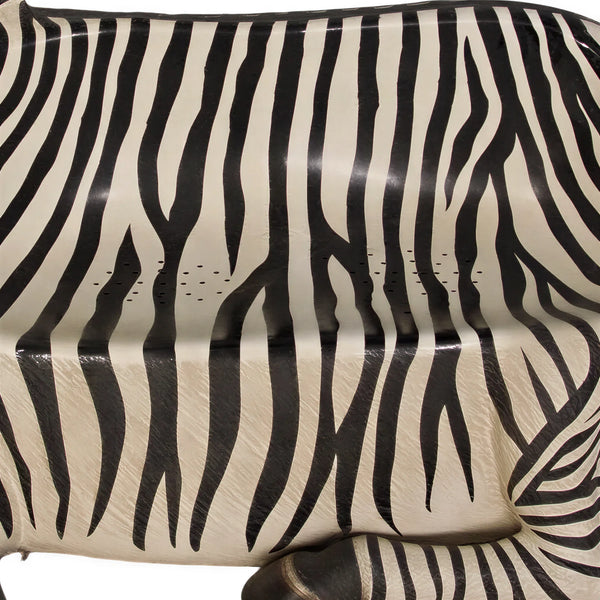 Decorative chair designed to look like a resting zebra with black and white stripes and an integrated seat.